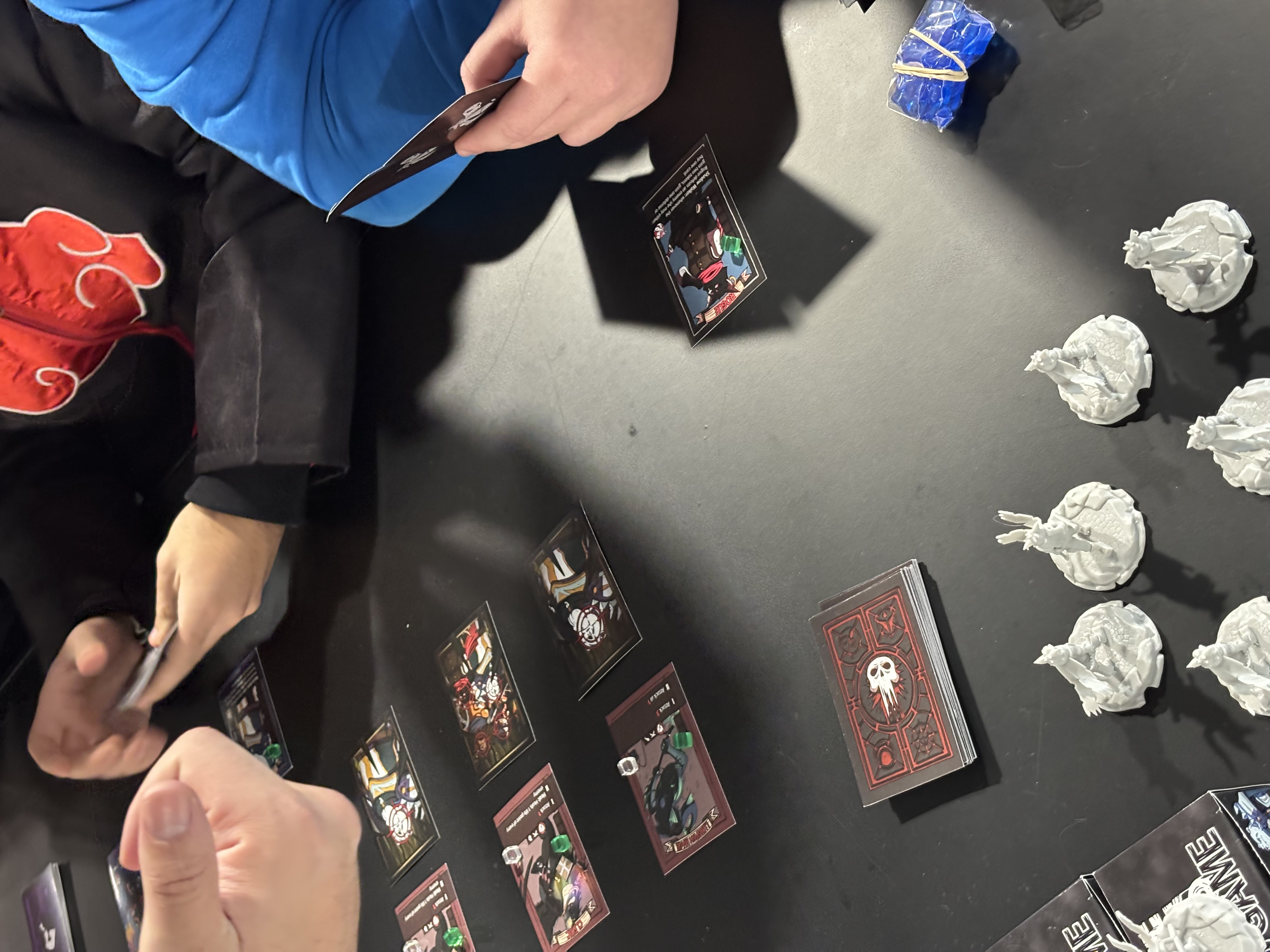 Rogue Reigns card game players leaning over a live playtest