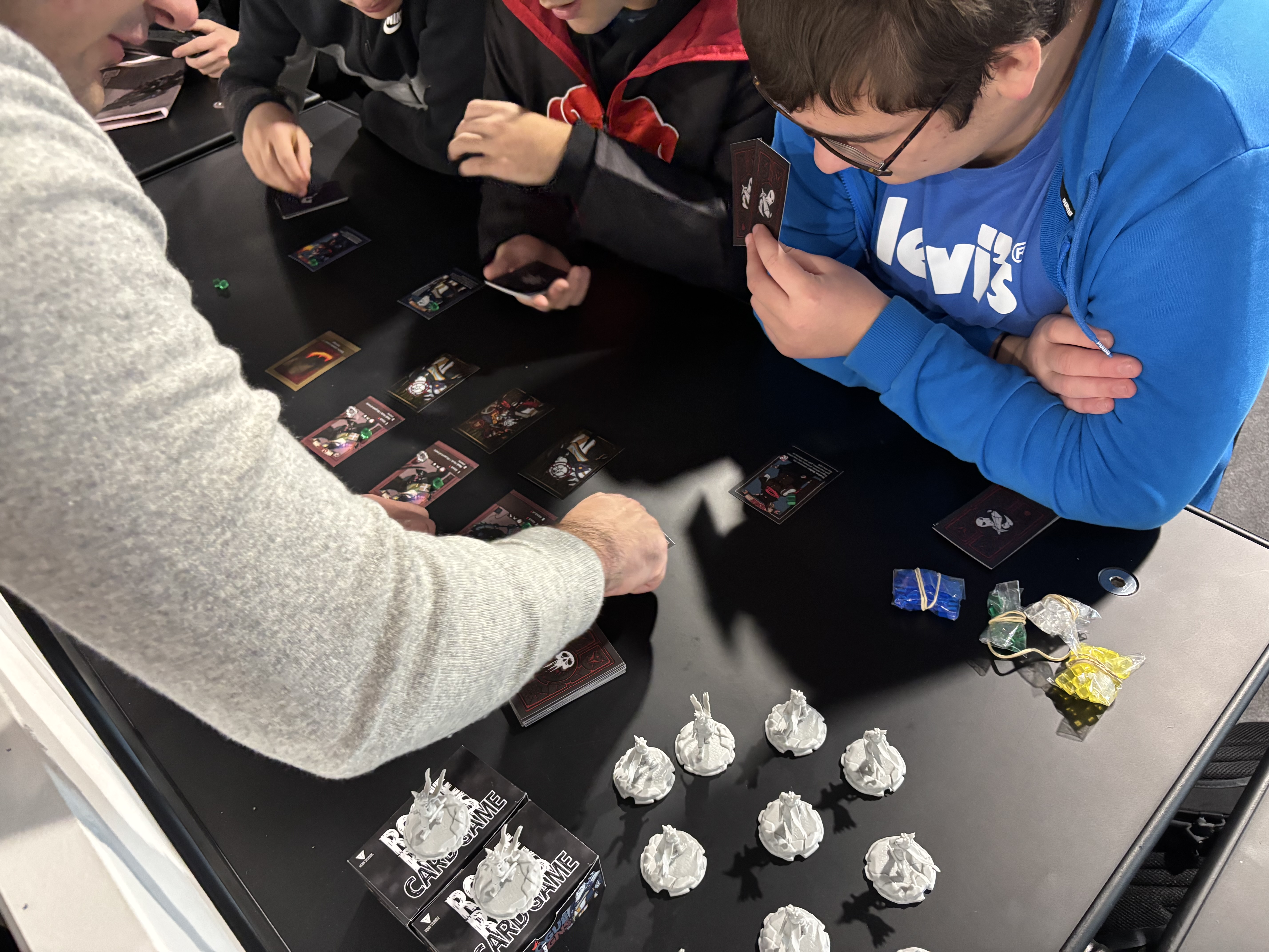 Players gathered around a Rogue Reigns card game playtest table