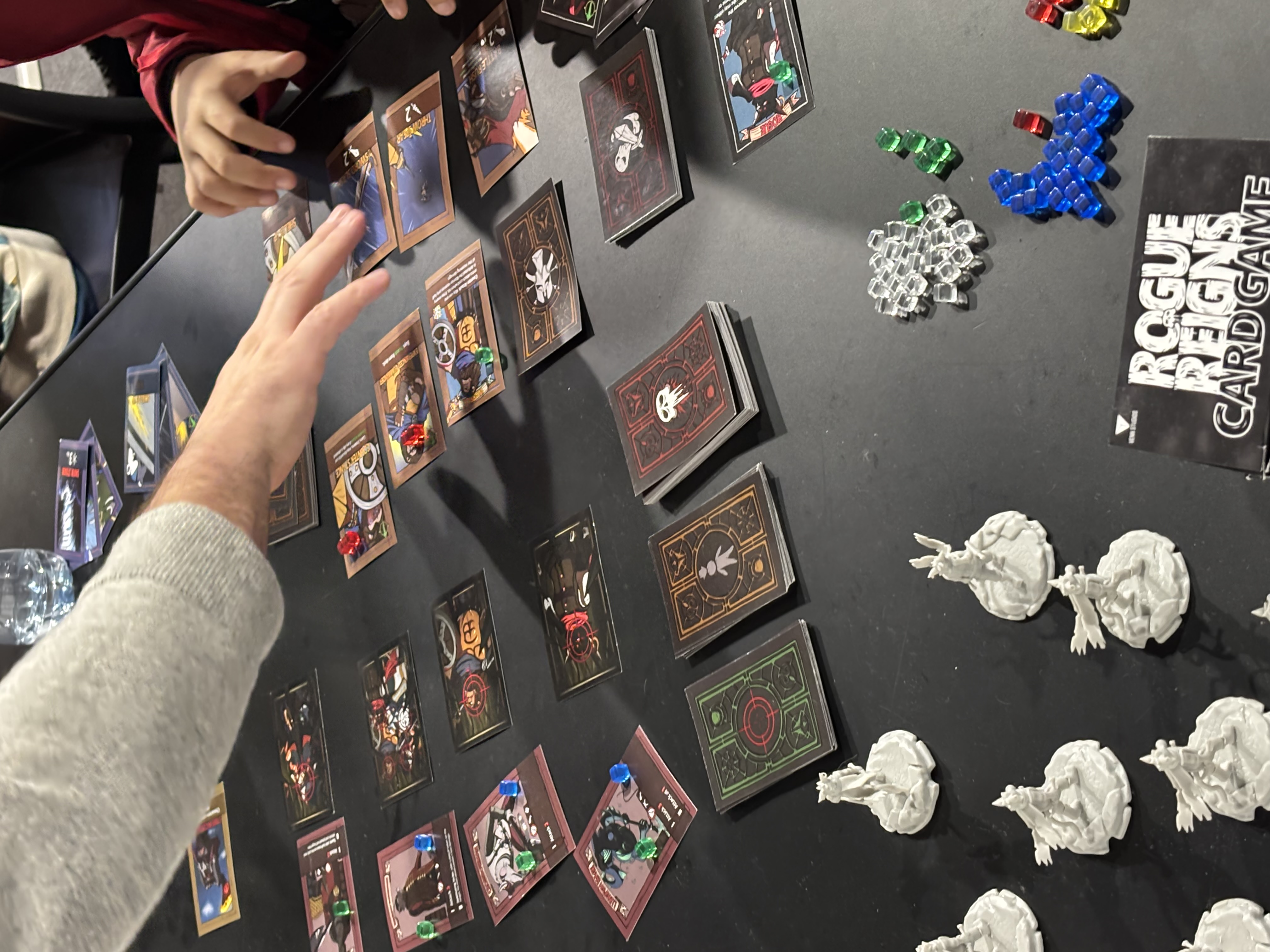 Rogue Reigns card game cards and miniatures during an active playtest